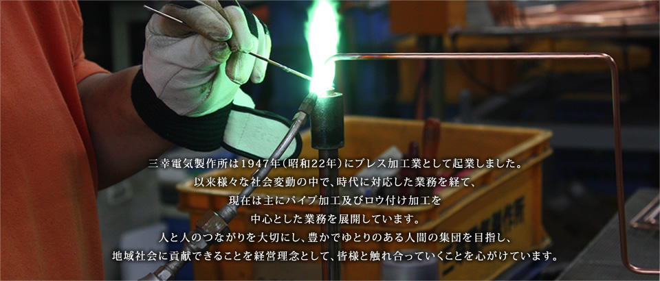 三幸電気製作所は1947年（昭和22年）にプレス加工業として起業しました。以来様々な社会変動の中で、時代に対応した業務を経て、現在は主にパイプ加工及びロウ付け加工を中心とした業務を展開しています。人と人のつながりを大切にし、豊かでゆとりのある人間の集団を目指し、地域社会に貢献できることを経営理念として、皆様と触れ合っていくことを心がけています。